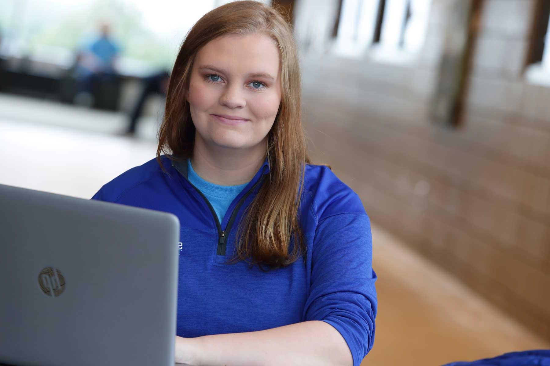 student in blue with laptop